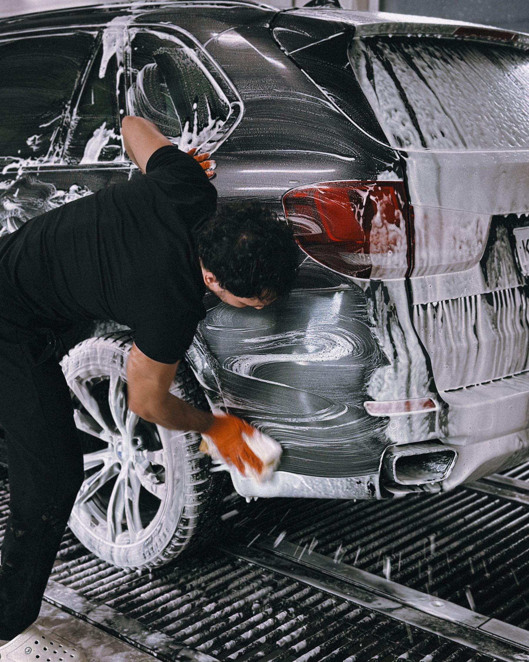 A dark vehicle being washed by hand